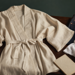 Veste kimono en lin crème sur pupitre bois, coutures visibles